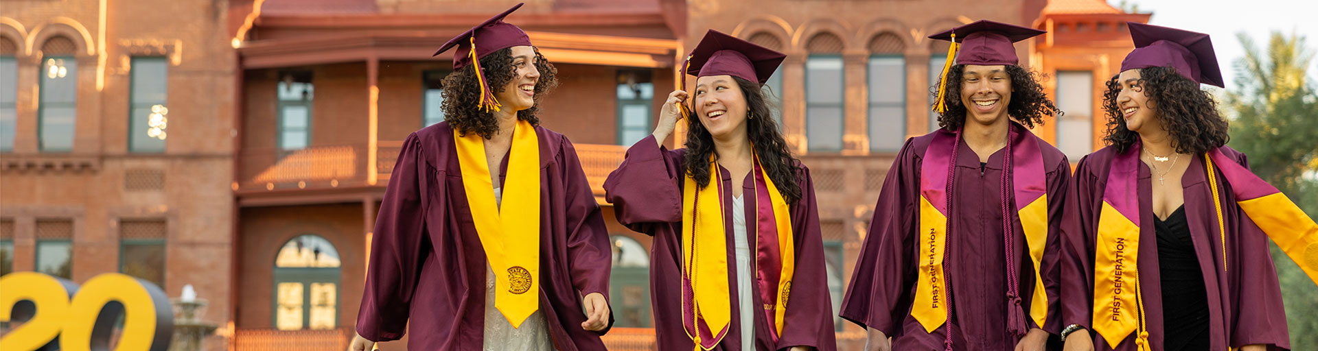 graduates celebrating outside of Old Main